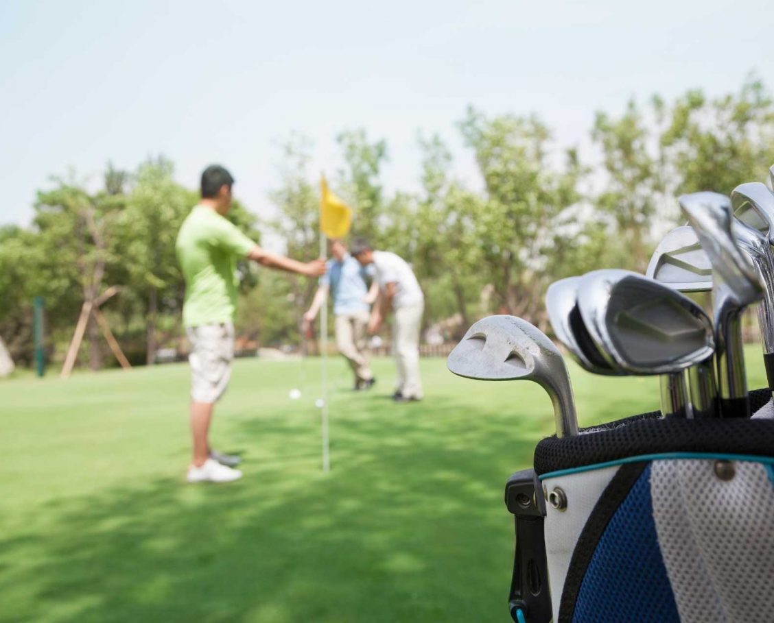 Men putting on the golf course